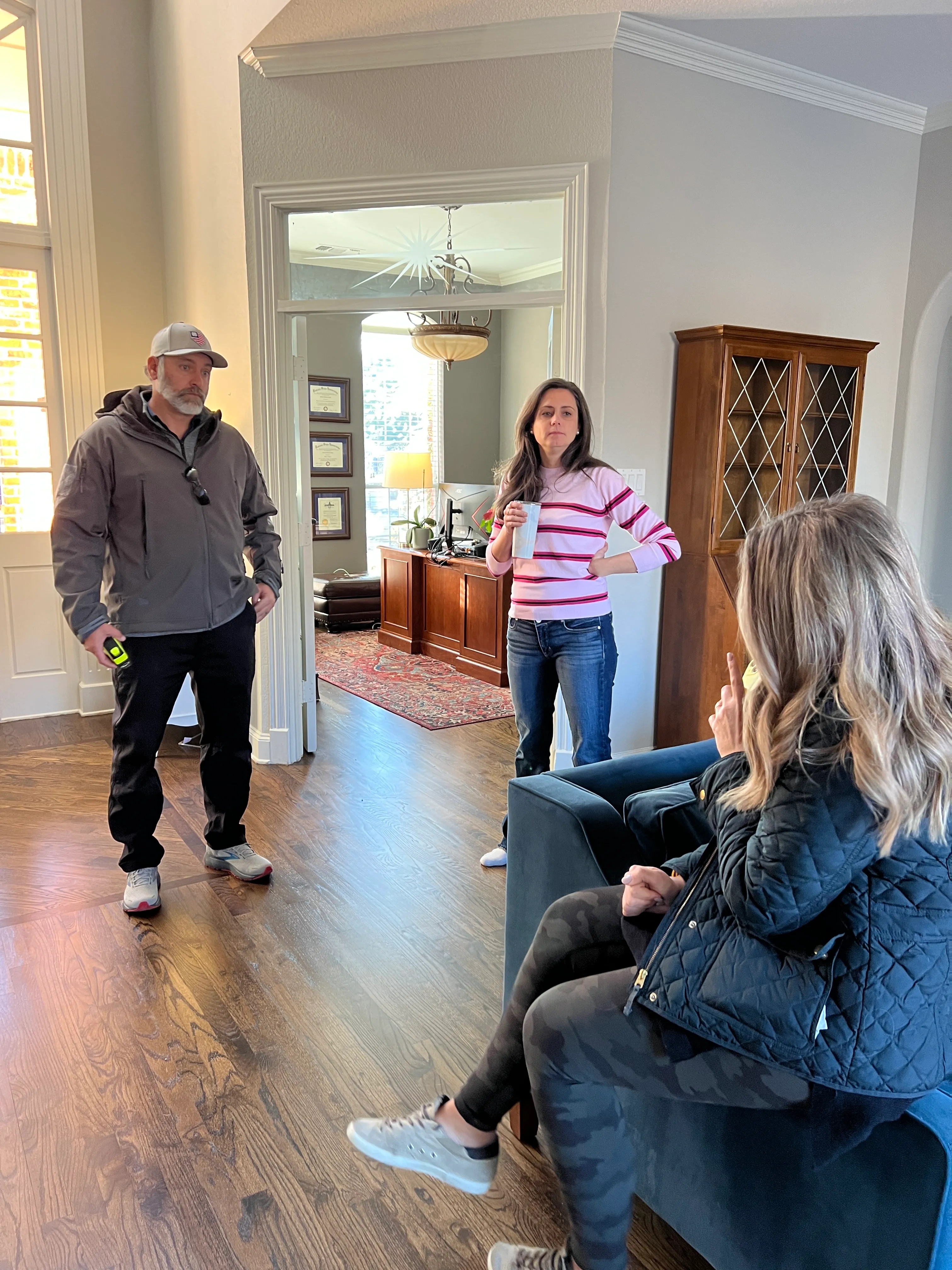 Chad reviewing plans with an interior designer and homeowner in a Keller entryway.